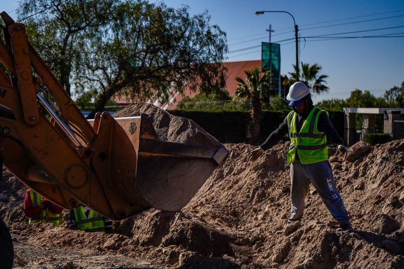 Con la iglesia de El Challao de fondo, un operario trabaja en un zanjeo como los que requerirá el nuevo sistema de provisión de agua potable en la zona norte del pedemonte de Mendoza