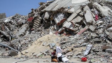 Franja de Gaza: un niño palestino sentado junto a los escombros de una casa destruída.