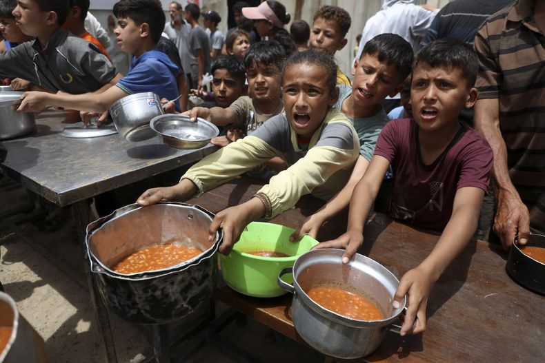 Niños palestinos reciben comida gratuita de una cocina comunitaria, en la Ciudad de Gaza, el 18 de mayo de 2026. Foto; NA