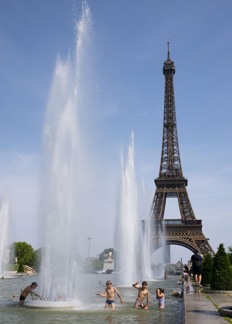 Los niños se refrescan y se relajan en una fuente frente a la Torre Eiffel en París, Francia, el 23 de junio de 2026. La Torre Eiffel de París cerró antes de lo previsto el martes debido a las altas temperaturas. Foto: NA (Xinhua/Wu Huiwo)