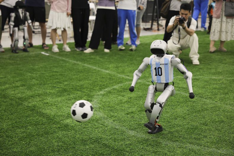 A robot plays football inside an embodied intelligence innovation industrial park in Zhongguancun, Haidian District of Beijing, capital of China, June 13, 2026. The embodied intelligence innovation industrial park is home to a number of brilliant players in this arena. Thanks to the high density of residing companies here, it is very easy for the players to find partners along the industrial chain -- literally by stepping up and down the stairways in the office building. (Xinhua/Wang Jingqiang)