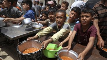 Niños palestinos reciben comida gratuita de una cocina comunitaria, en la Ciudad de Gaza, el 18 de mayo de 2026. Foto; NA