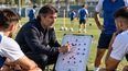 Entrenador explica una táctica durante una sesión de fútbol