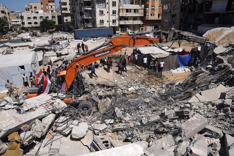 Equipos de Defensa Civil palestinos buscan cuerpos y sobrevivientes entre los escombros de un edificio colapsado que albergaba a palestinos desplazados, en la Ciudad de Gaza, (Xinhua/Rizek Abdeljawad)